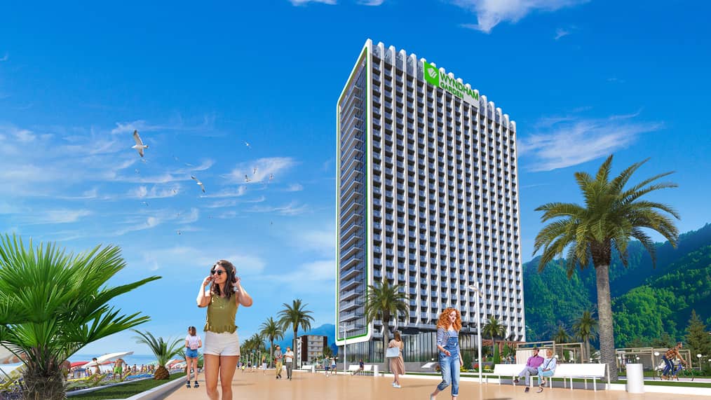 Архитектурная 3D-визуализация многоэтажного отеля Wyndham Garden, расположенного на солнечной набережной с пальмами и прогуливающимися людьми.